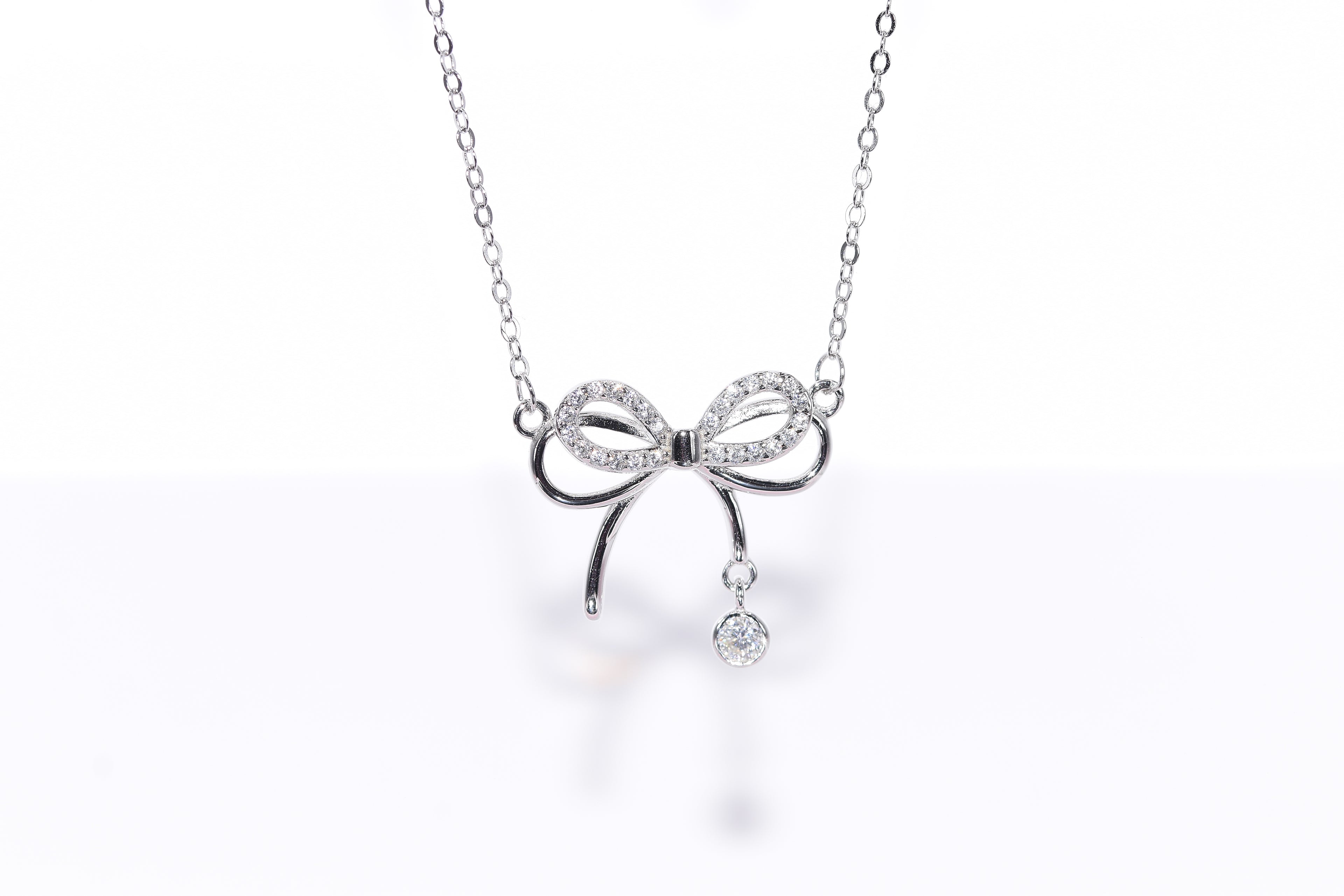Dainty Bow moissanite necklace angle view delicate silver bow pendant Australia — Byrall
