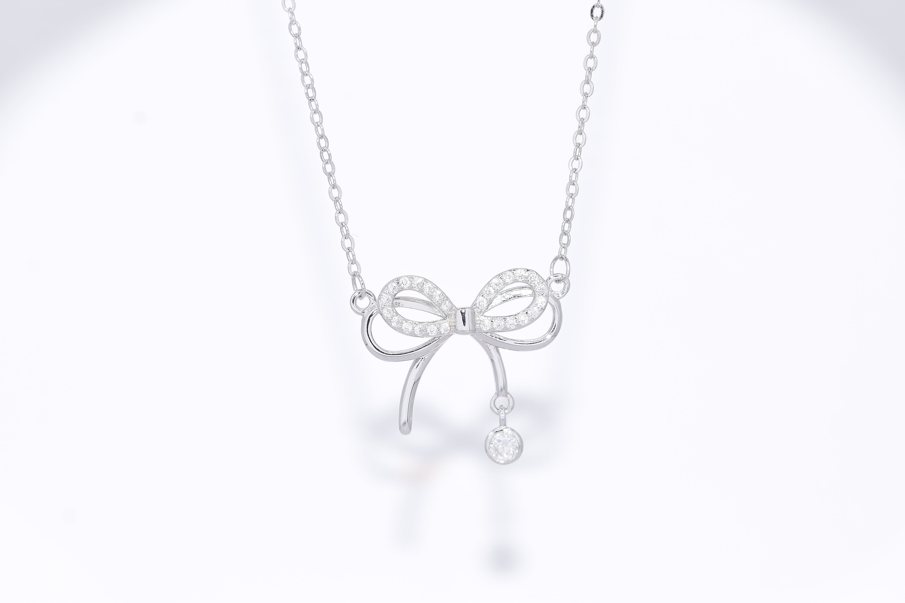 Woman wearing Dainty Bow moissanite necklace silver, everyday bow pendant gift for her Australia — Byrall